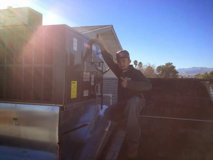 HVAC technician performing Air Duct Repair on a rooftop unit in Parkland